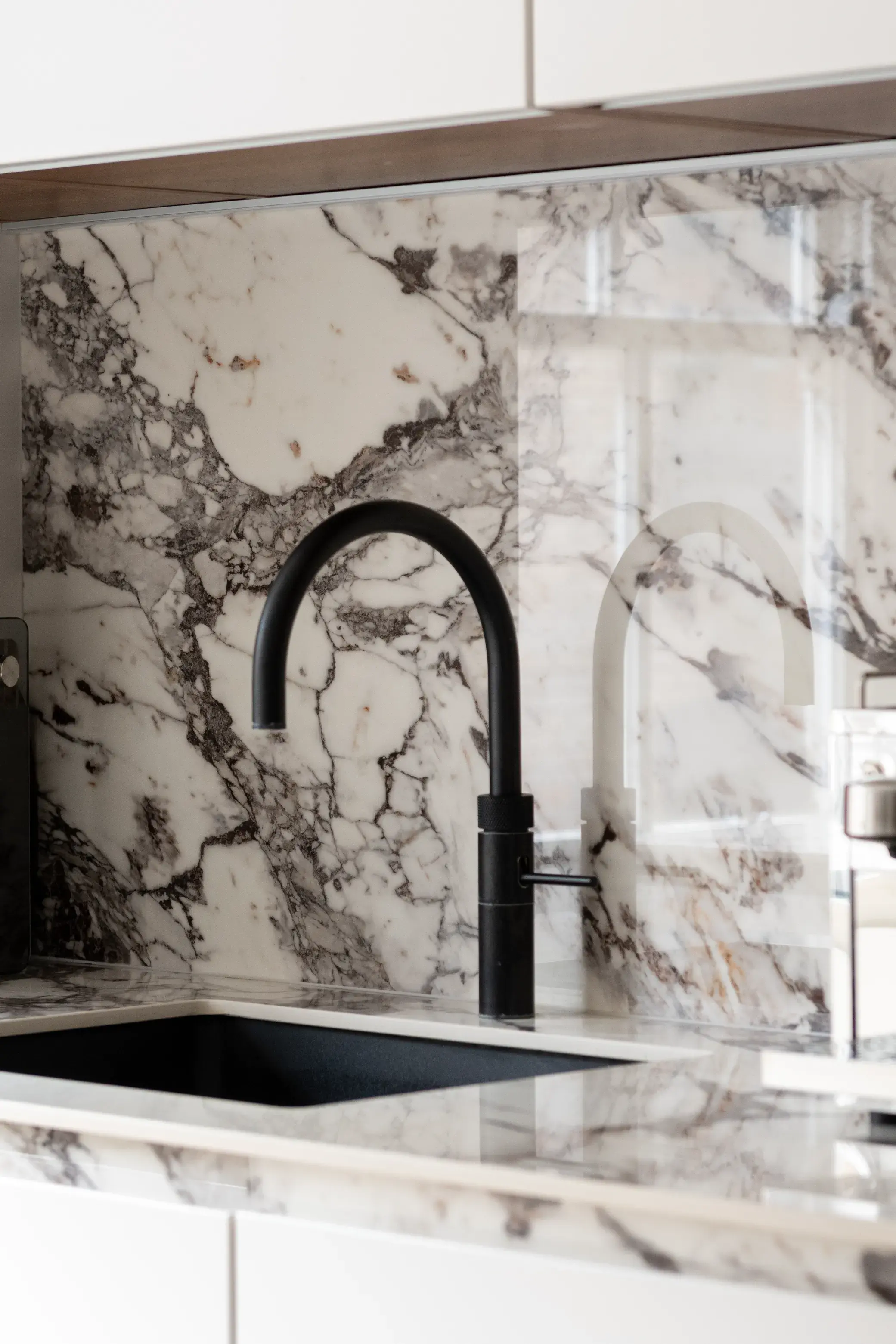 Black tap and marble splashback detail in the Floral Street Apartment kitchen